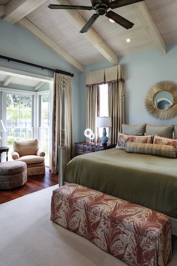 The pine beams and vaulted ceiling of the great room are repeated here in the master bedroom, but in a softer whitewashed finish befitting the more subdued atmosphere.
