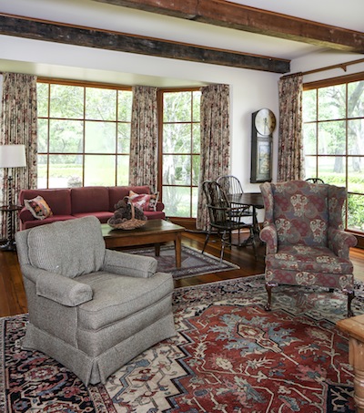 Interior designer Jo Emmert gave the living room a classic yet casual style. Masculine-influenced fabrics like hunting tweeds and kilim pillows complement warm natural wood accents.