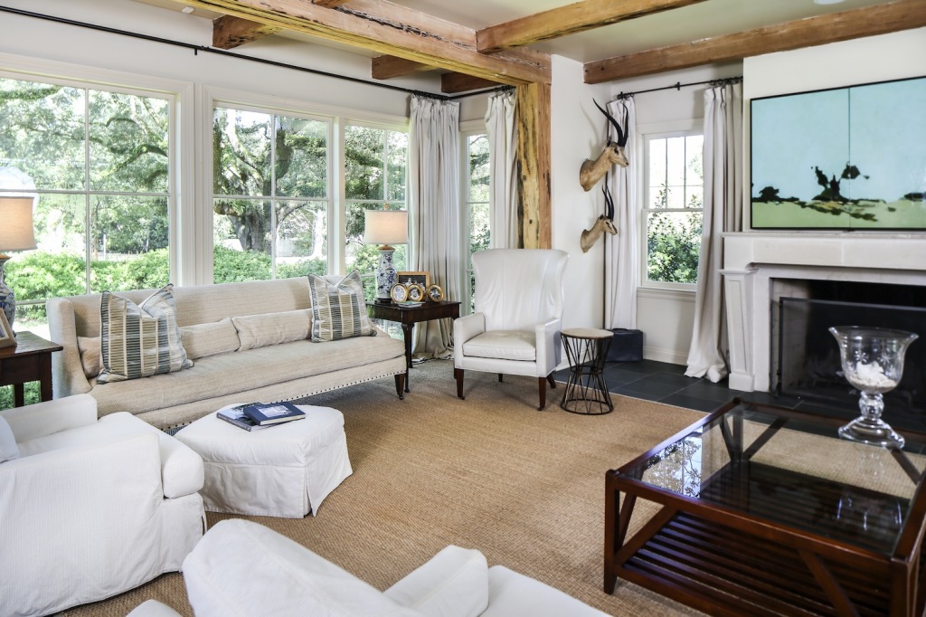 The family room, which was part of the 1,200-square-foot addition, frames a fantastic view of the old oak tree outside. The painting over the fireplace was done by Lisa DiStefano in two parts to hide a recessed TV. 