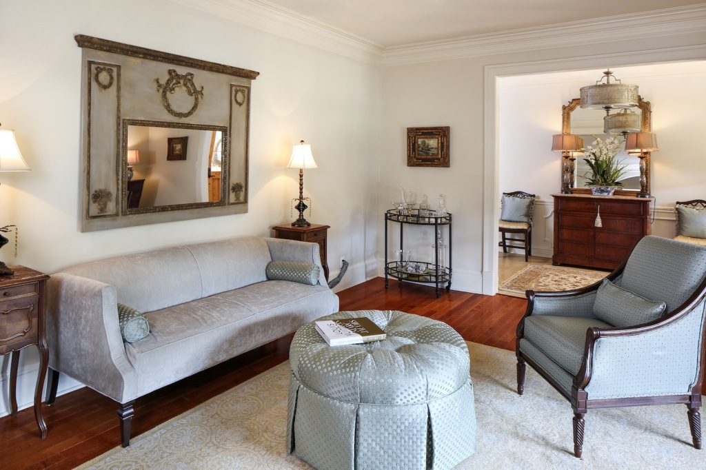 A reproduction Trumeau mirror is a focal point in the formal living room, which is all dressed up with a skirted ottoman and low-slung velvet sofa. Like most of the home’s furnishings, these pieces came from The Royal Standard. Photos by Melissa Oivanki.