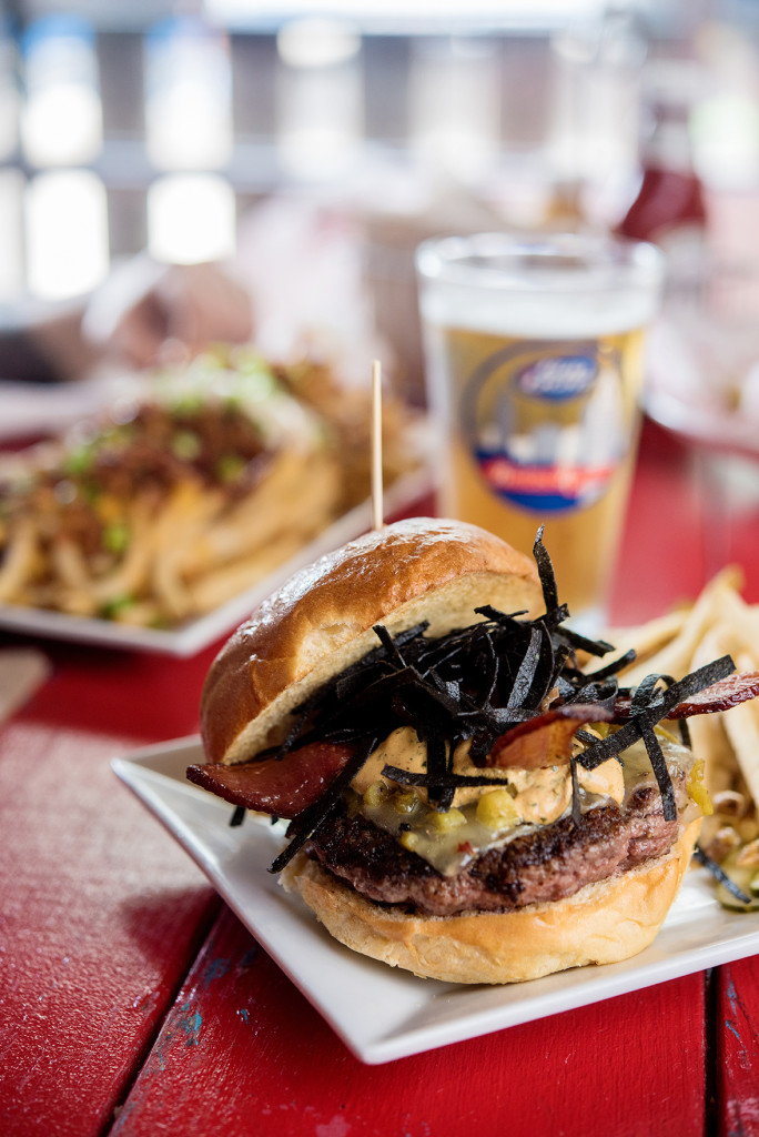 The Green Chili Cheeseburger at Barcadia is loaded with roasted green chilies, pepper jack cheese, crunchy tortilla strips, cilantro crema and bacon.