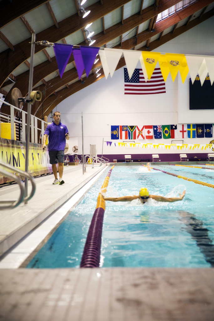 LSU swimming coach Dave Geyer walks along the pool during a swimming practice.